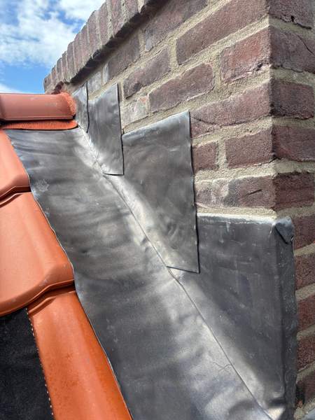 Loodaansluiting rond een schoorsteen