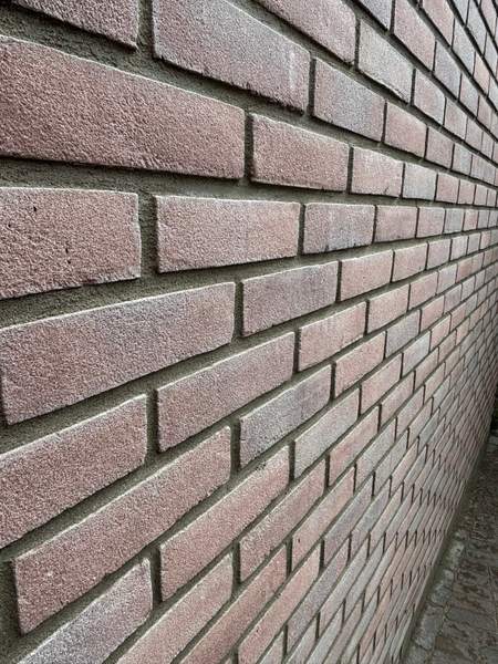 Detail van de tuinmuur: de terugliggende voeg geeft schaduw